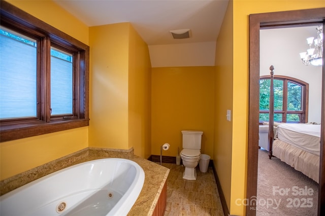 bathroom with toilet and a tub to relax in