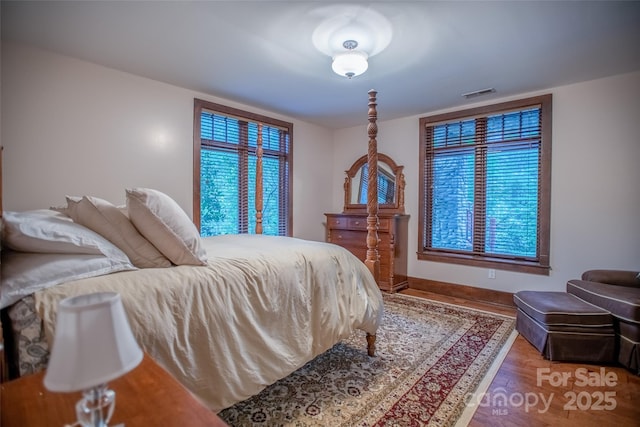 bedroom featuring wood-type flooring and multiple windows