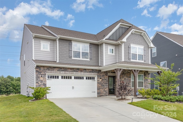 craftsman inspired home featuring a garage and a front yard