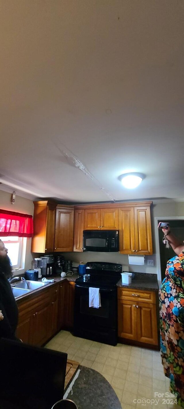 kitchen featuring sink, black appliances, and light tile patterned floors