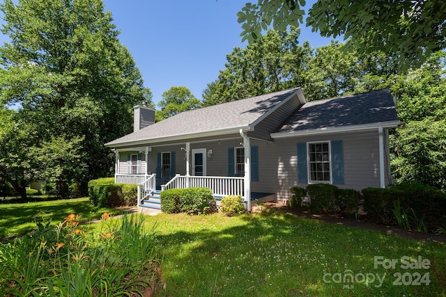 ranch-style home featuring covered porch and a front yard