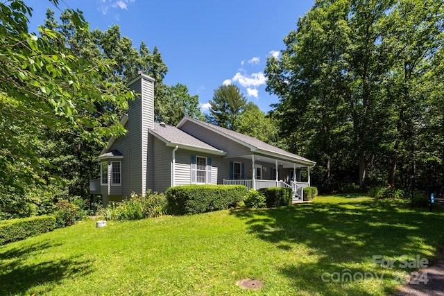 view of home's exterior featuring covered porch and a yard