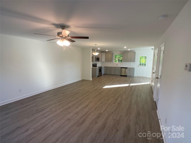 unfurnished living room featuring dark hardwood / wood-style floors, ceiling fan, and sink