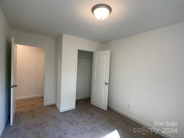 unfurnished bedroom with light carpet and a closet