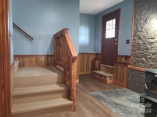 stairway with a wood stove and hardwood / wood-style flooring