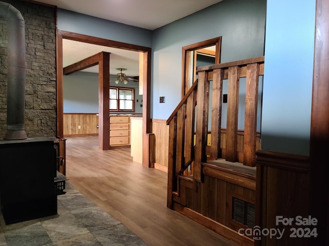 hall featuring wood-type flooring and wood walls