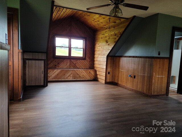 bonus room featuring lofted ceiling, wood ceiling, wood walls, and hardwood / wood-style floors