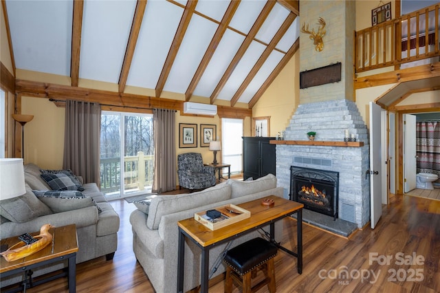 living room featuring hardwood / wood-style flooring, a stone fireplace, high vaulted ceiling, and a wall mounted AC