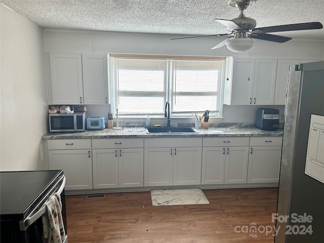 kitchen with a healthy amount of sunlight, white cabinetry, sink, and stainless steel appliances