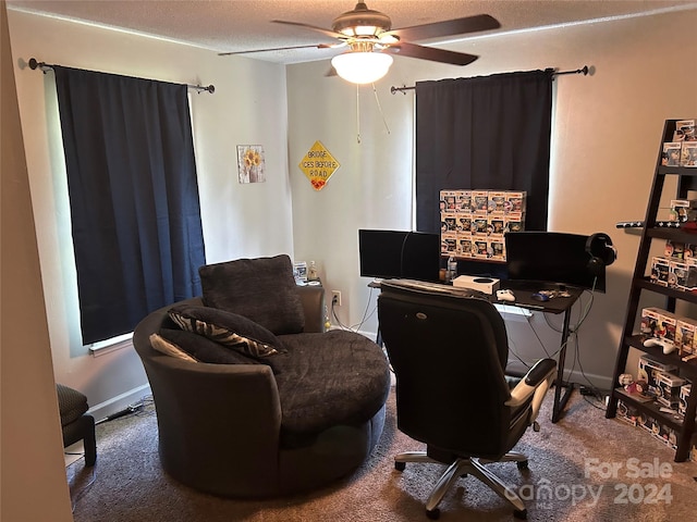 carpeted home office with ceiling fan and a textured ceiling