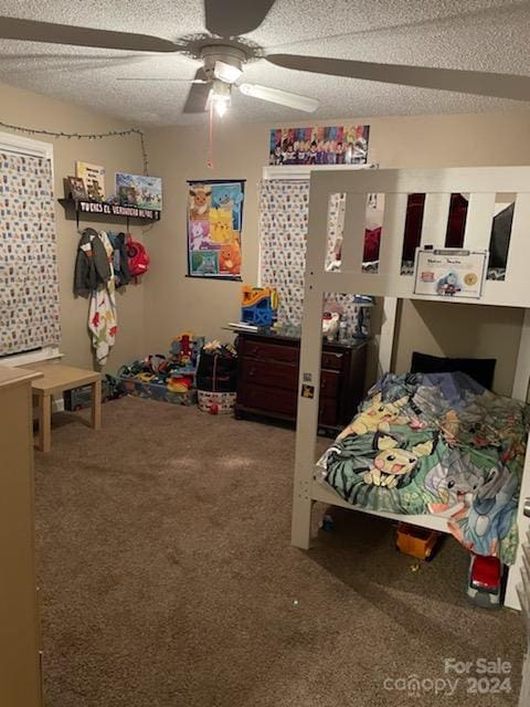 bedroom with ceiling fan, carpet floors, and a textured ceiling