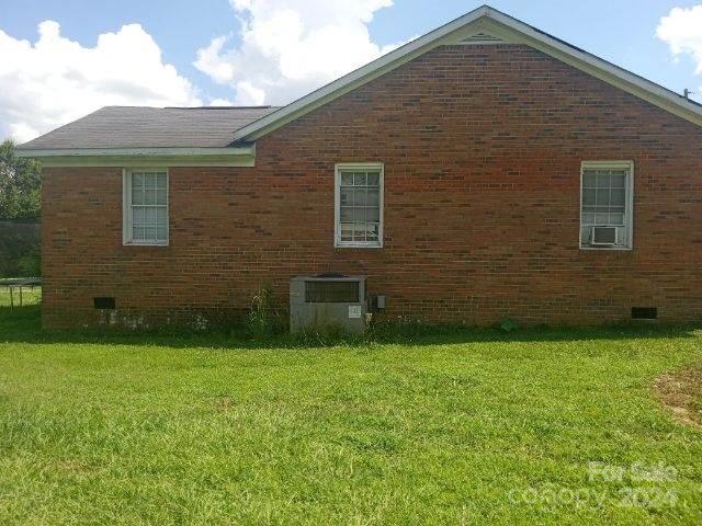 view of side of property with central AC unit and a yard