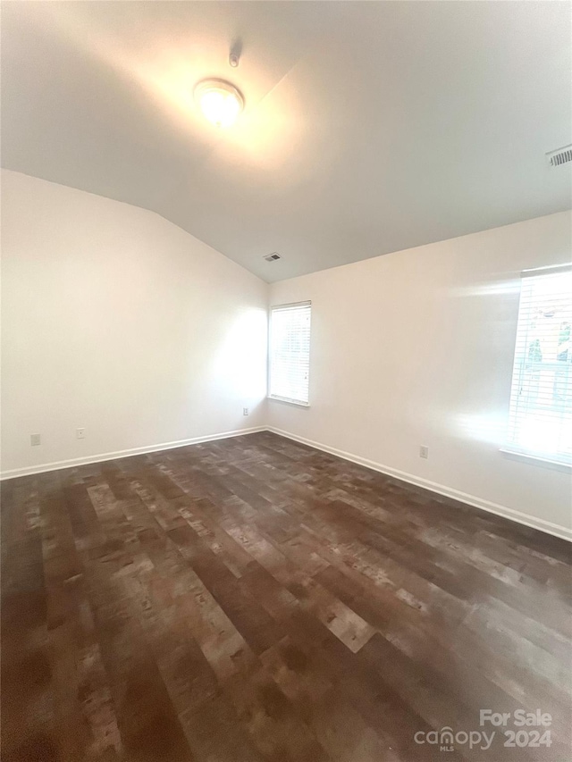 empty room with lofted ceiling and dark hardwood / wood-style floors