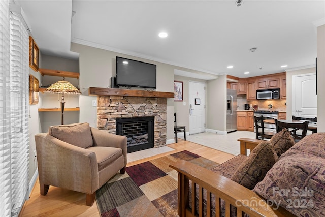 living room with a fireplace, light hardwood / wood-style floors, and ornamental molding