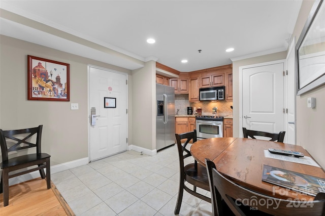 dining area with light tile patterned floors and crown molding