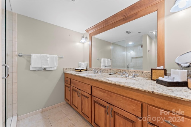 bathroom with tile patterned flooring, vanity, and walk in shower