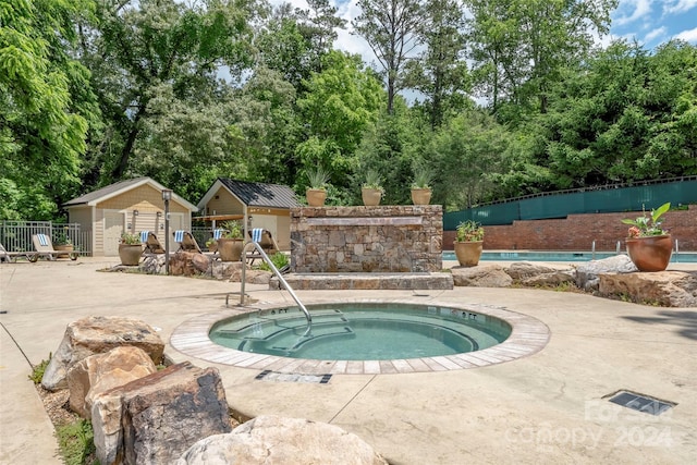 view of pool with a community hot tub and a shed