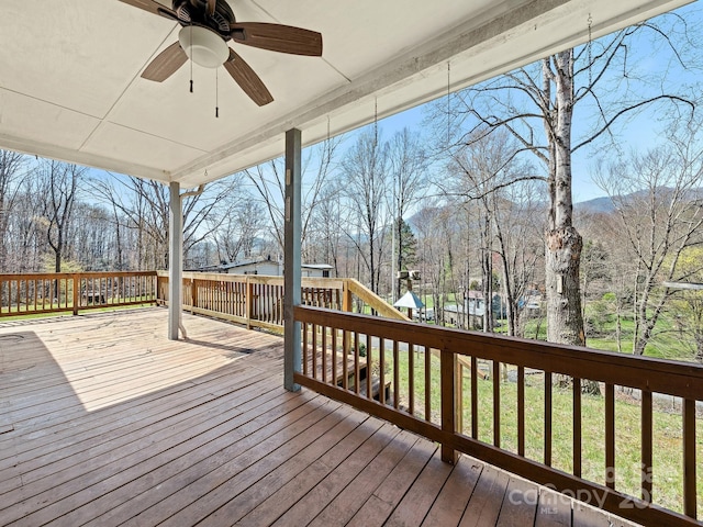 wooden deck featuring ceiling fan and a playground