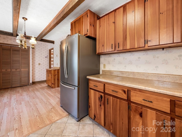 kitchen with decorative light fixtures, a chandelier, light tile patterned floors, stainless steel refrigerator, and beamed ceiling