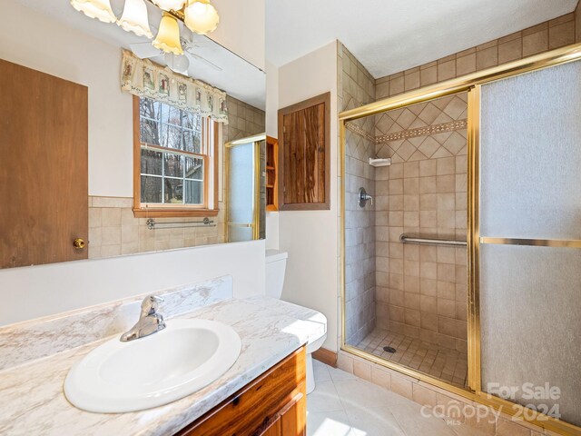 bathroom featuring tile floors, a shower with shower door, and vanity