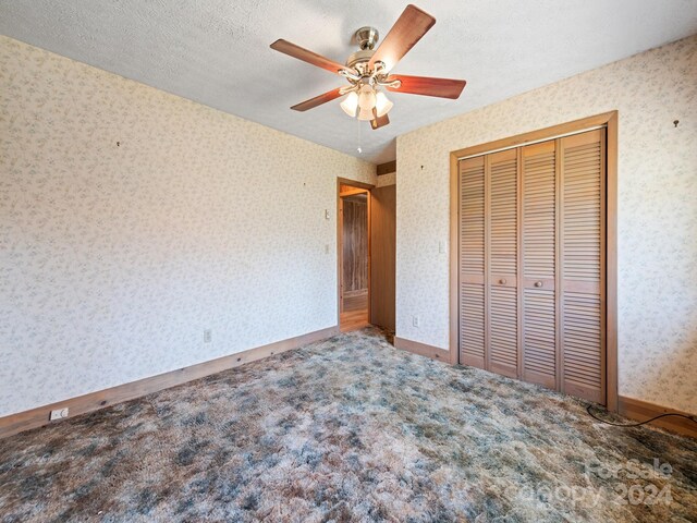 unfurnished bedroom featuring a textured ceiling, a closet, ceiling fan, and carpet floors