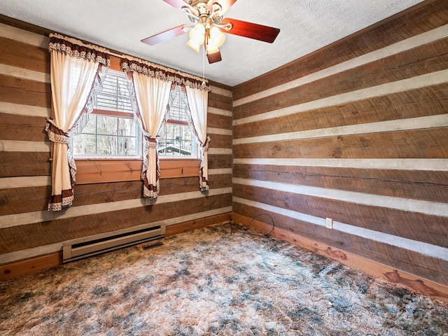 unfurnished room with a baseboard heating unit, a textured ceiling, and wooden walls