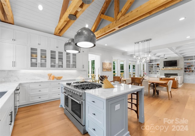 kitchen with double oven range, backsplash, a kitchen island, a kitchen bar, and white cabinetry