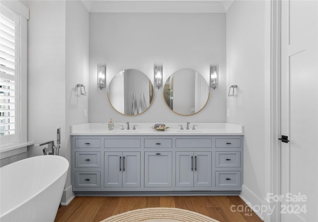 bathroom with hardwood / wood-style flooring, a bathtub, and vanity