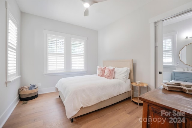 bedroom featuring light wood-type flooring, ceiling fan, and sink