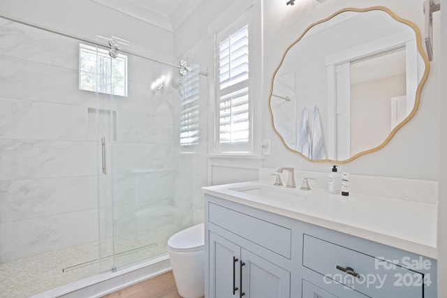 bathroom with hardwood / wood-style flooring, a shower with door, vanity, and toilet