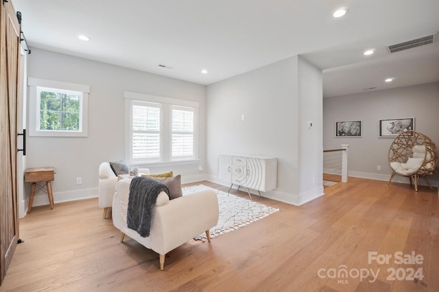 sitting room featuring a barn door and light wood-type flooring