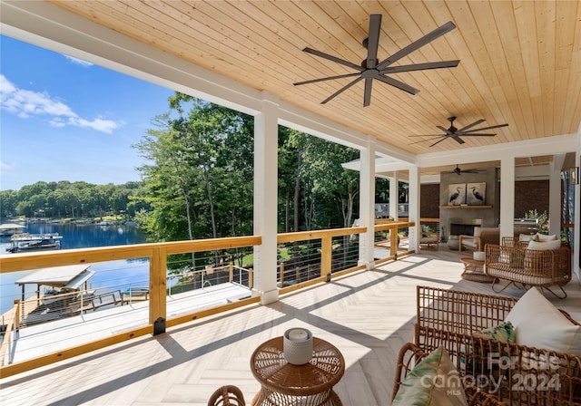 view of patio / terrace with a water view and exterior fireplace