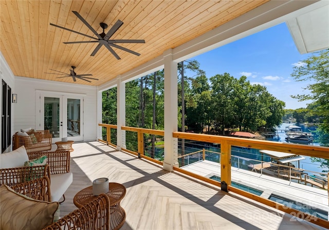 exterior space with ceiling fan, a water view, and french doors