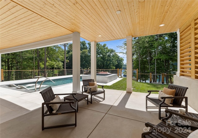 view of patio featuring pool water feature and a pool with hot tub