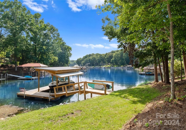 dock area featuring a lawn and a water view