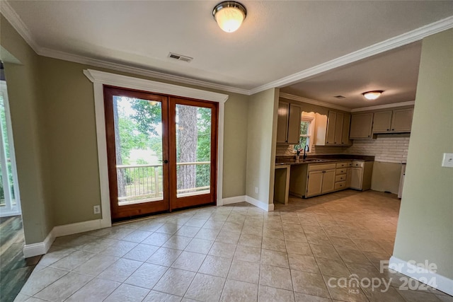 kitchen with decorative backsplash, sink, light tile patterned floors, and crown molding