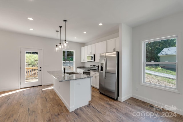 kitchen featuring a center island with sink, white cabinetry, sink, and appliances with stainless steel finishes