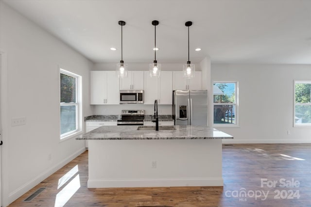 kitchen featuring white cabinets, stainless steel appliances, a healthy amount of sunlight, and sink