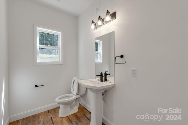 bathroom featuring hardwood / wood-style floors, toilet, and a wealth of natural light