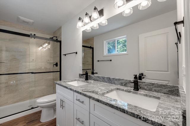 bathroom featuring vanity, hardwood / wood-style flooring, toilet, and walk in shower