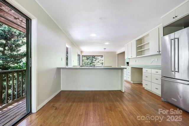 kitchen with kitchen peninsula, white cabinetry, and high quality fridge