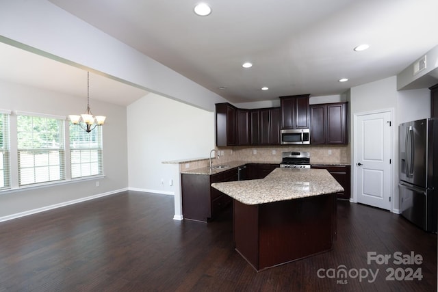 kitchen featuring appliances with stainless steel finishes, pendant lighting, tasteful backsplash, and a center island