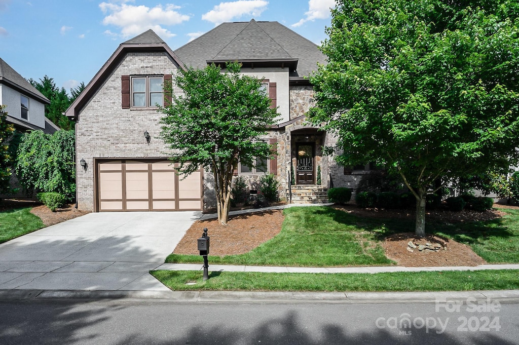 view of front of property with a garage and a front lawn