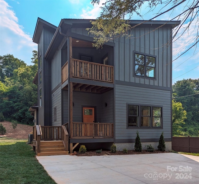 view of front of house featuring a balcony and central air condition unit