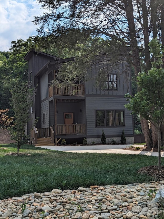 view of front of house with a front yard and a balcony