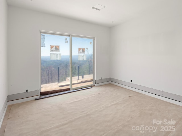 unfurnished room with baseboards and concrete floors