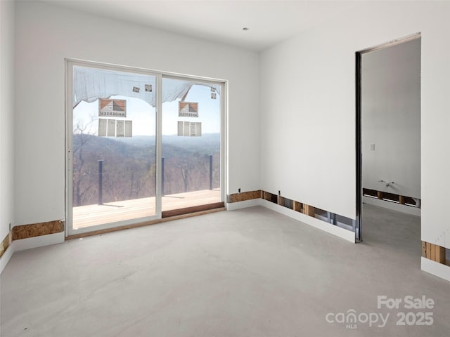 empty room with baseboards and finished concrete flooring