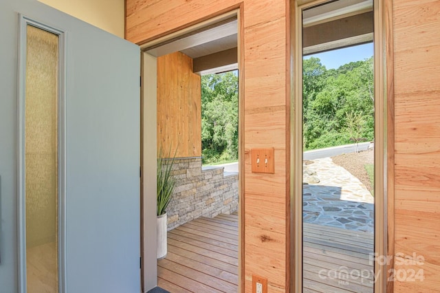 doorway to outside featuring wooden walls