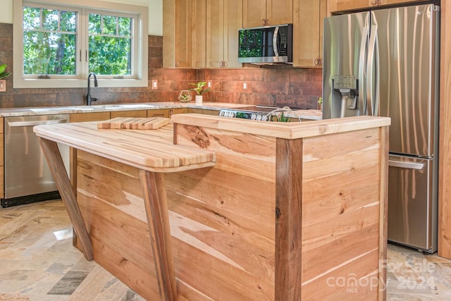 kitchen with backsplash, sink, and stainless steel appliances