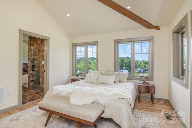 bedroom with connected bathroom, lofted ceiling with beams, and light hardwood / wood-style floors